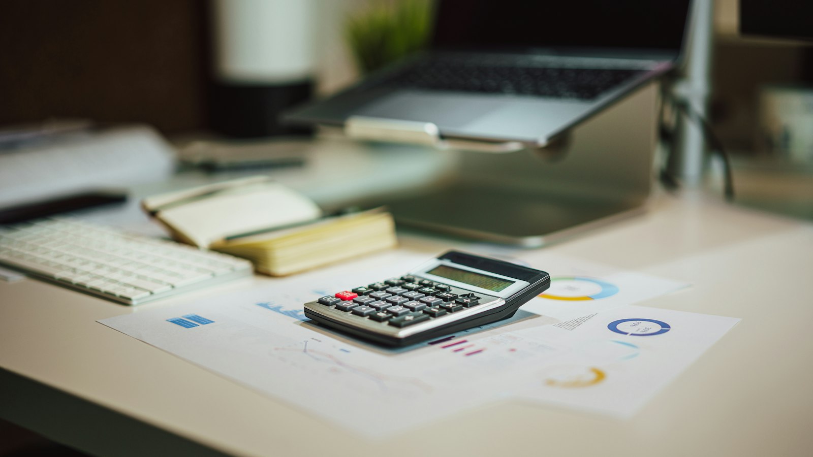 A calculator and financial documents on an office desk