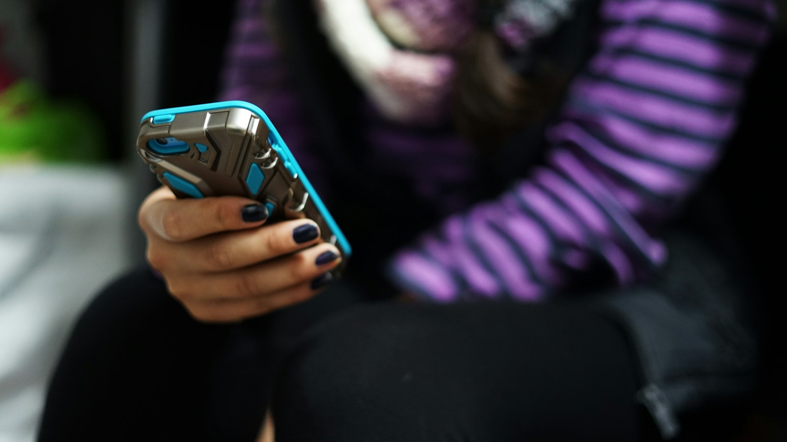 A young person holding and looking at a smartphone
